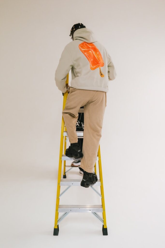 a man sitting on a yellow step ladder